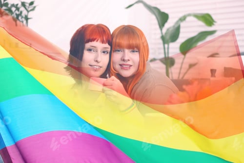 Preview: Lovely lesbian couple together at home, double exposure with pride flag. LGBT concept