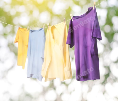 Preview: Clothes drying on laundry line outdoors against blurred tree during sunny day
