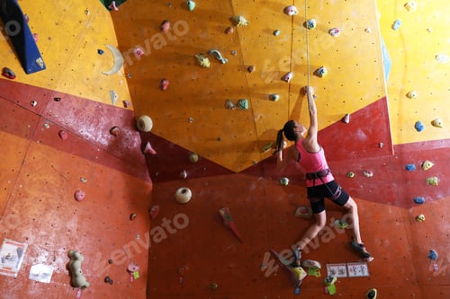 Preview: Athletic woman climbing wall in gym, back view. Space for text
