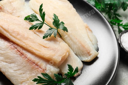 Preview: Plate with raw cod fish and parsley on table, closeup