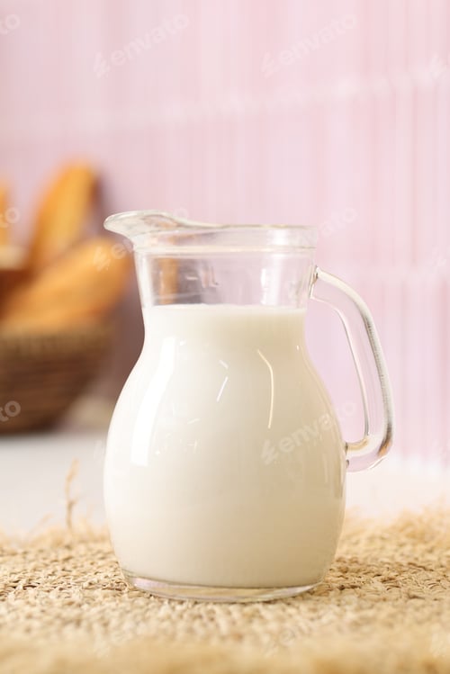 Preview: Fresh milk in glass jug on countertop indoors, closeup