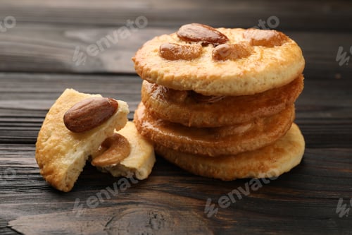 Preview: Stack of delicious cookies with nuts and pieces on wooden table, closeup