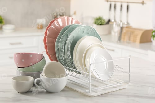 Preview: Many different clean dishware and cups on white marble table in kitchen