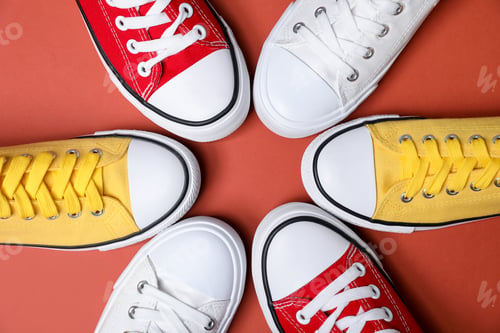 Preview: Frame of beautiful sneakers on coral background, flat lay. Space for text