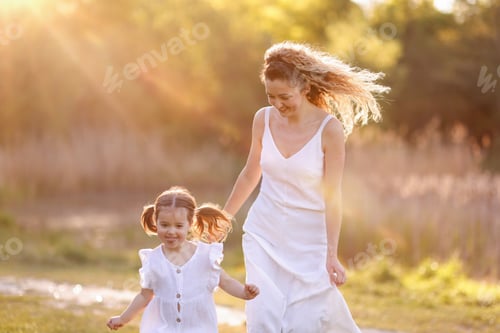 Preview: Mother with her cute little daughter running in nature on sunny day