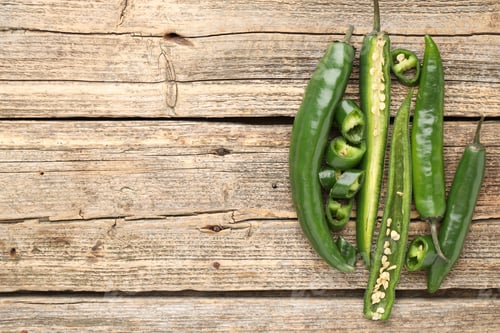 Preview: Fresh chili peppers on wooden table, flat lay. Space for text