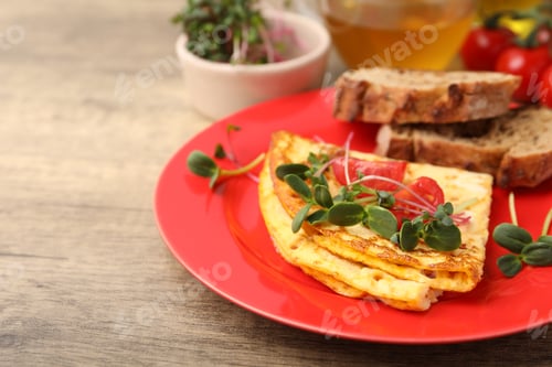 Preview: Tasty breakfast with omelette, microgreens, tomatoes, bread and tea on wooden table, closeup. Space