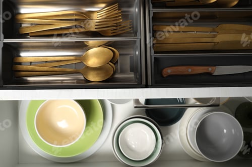 Preview: Ceramic dishware and cutlery in drawers indoors, top view