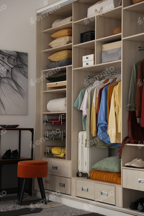 Preview: Large wardrobe with clothes, shoes, home textile and suitcase indoors