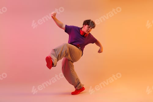 Preview: Young man performing hip-hop dance on color background