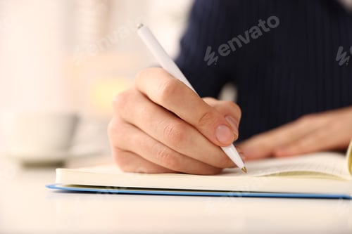 Preview: Woman writing in notebook with pen at table, closeup