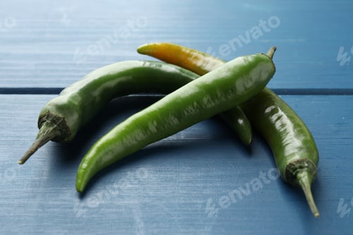 Preview: Hot green chili peppers on blue wooden table, closeup