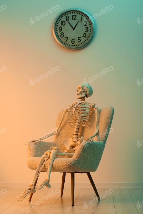 Preview: Waiting concept. Human skeleton sitting in armchair indoors