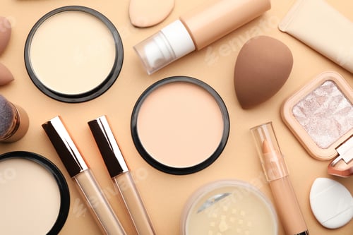 Preview: Face powders, foundation, concealers and sponges on beige background, flat lay
