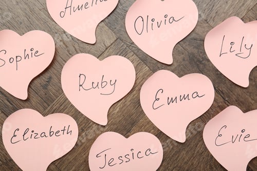 Preview: Paper stickers with different names on wooden background, flat lay. Choosing baby's name