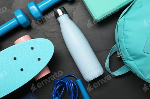 Preview: Different sports equipment on black table, flat lay