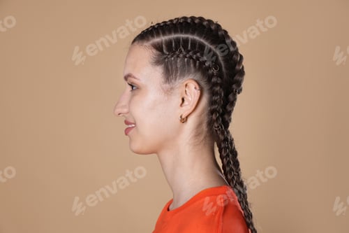 Preview: Smiling teenage girl with beautiful braids on beige background