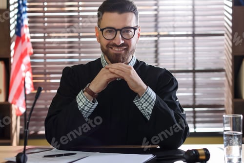 Preview: Portrait of smiling judge in glasses at table in office