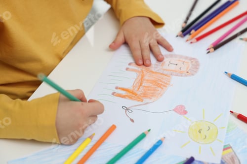 Preview: Little boy drawing lion with pencil at table, closeup
