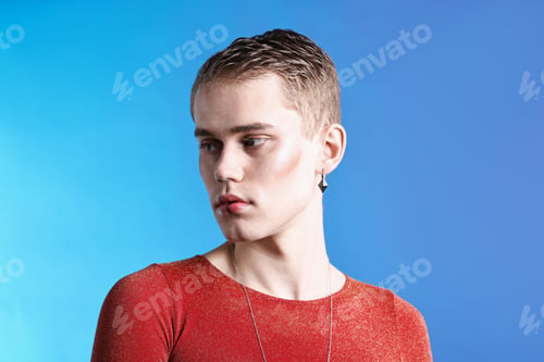 Preview: Young man with piercings on light blue background