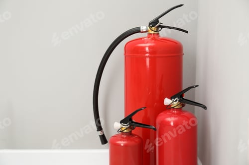 Preview: Three fire extinguishers near light grey wall