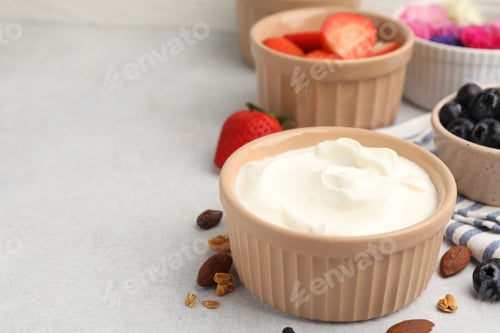 Preview: Fresh ingredients for yogurt bark on light grey table, closeup. Space for text