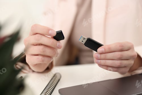 Preview: Woman with USB flash drive at desk, closeup