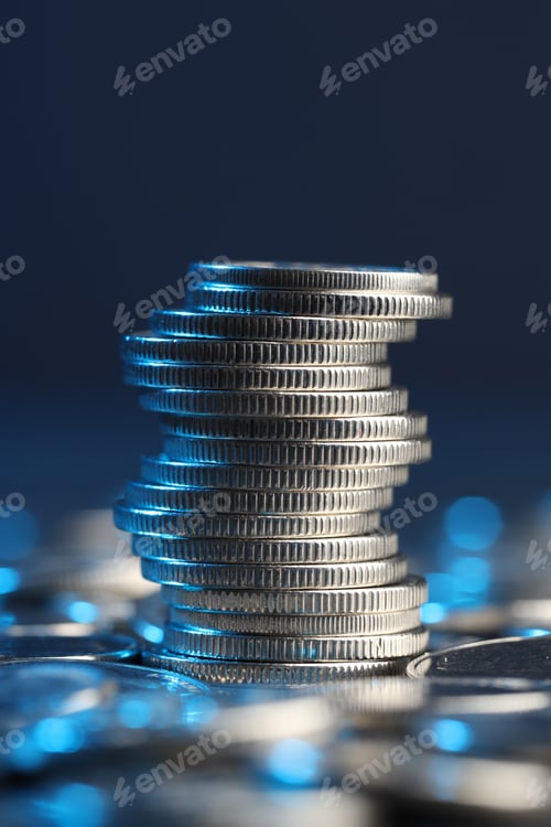 Preview: Many stacked coins on table against blurred background, closeup