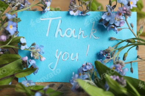 Preview: Card with phrase Thank You and beautiful forget-me-not flowers on table, closeup