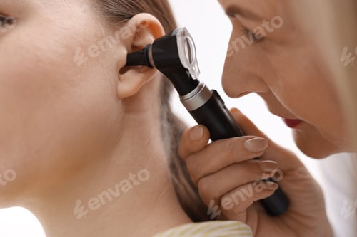 Preview: Hearing test. Doctor examining patient’s ear with otoscope in clinic, closeup