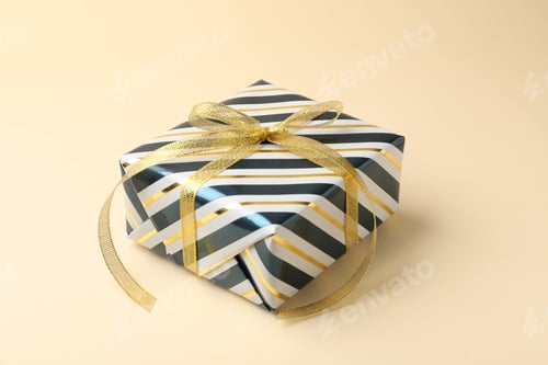 Preview: Beautiful wrapped gift box on beige background, closeup