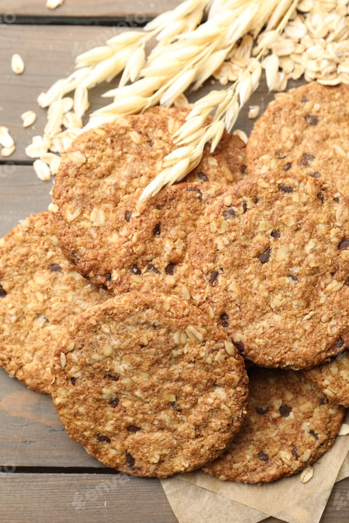 Preview: Delicious oatmeal cookies, oat flakes and spikes on wooden table, flat lay