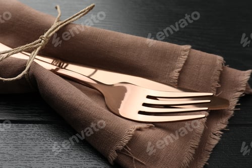 Preview: Stylish setting with cutlery and napkin on black wooden table, closeup