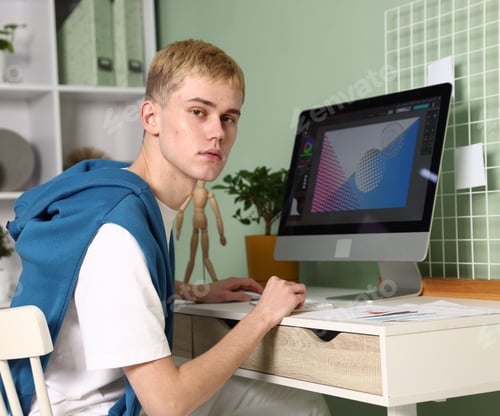 Preview: Designer working on computer at table in office