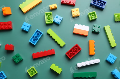 Preview: Construction toy. Colorful building blocks on green background, flat lay