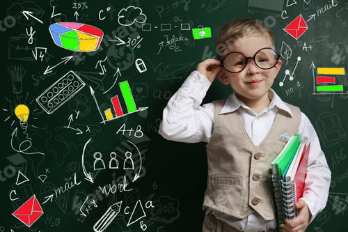 Preview: Cute little child in glasses near green chalkboard with drawings
