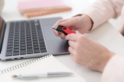 Preview: Woman with USB flash drive at desk, closeup