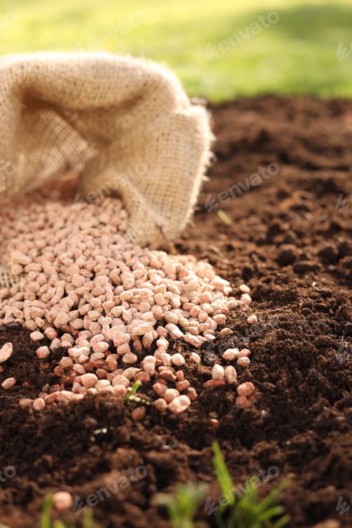 Preview: Granulated fertilizer in sack on soil, closeup
