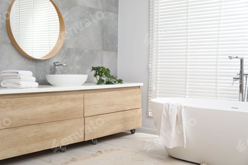 Preview: Stylish bathroom with bath tub, vanity, towels and houseplant