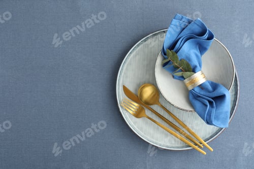 Preview: Stylish setting with cutlery, dishes, napkin and floral decor on table, top view. Space for text