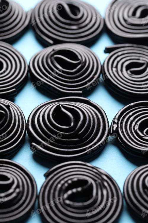 Preview: Natural licorice candies on light blue background, closeup