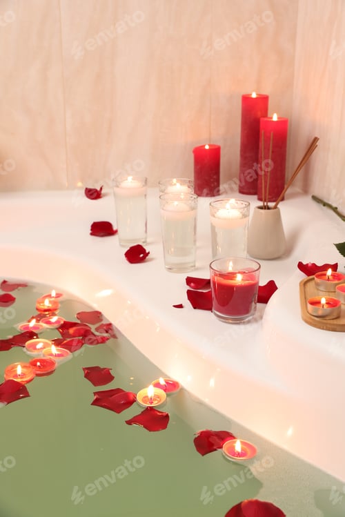 Preview: Romantic atmosphere. Bathtub with burning candles, petals and air reed freshener in bathroom, closeu