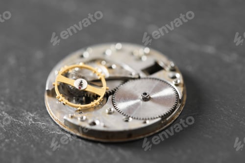 Preview: Mechanism of vintage wrist watch on black table, closeup