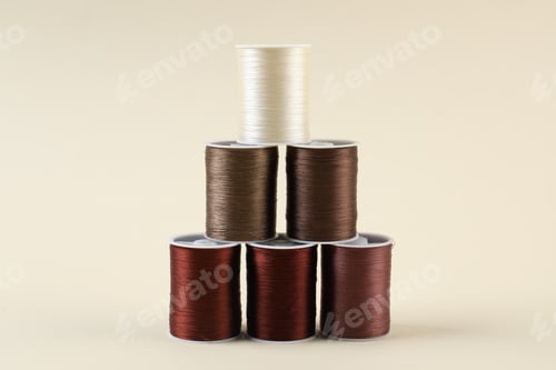 Preview: Spools of sewing threads on beige background