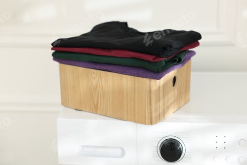 Preview: Clean laundry in crate on washing machine indoors, closeup