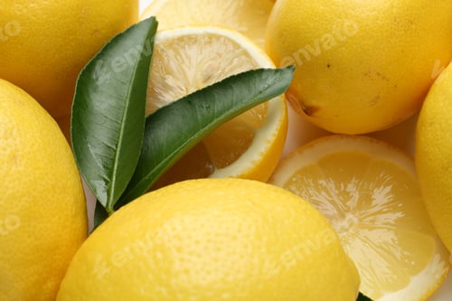 Preview: Fresh lemon fruits and green leaves on white background, closeup