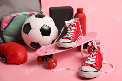 Preview: Penny board, sneakers, water bottle, backpack and sports equipment on pink background, closeup