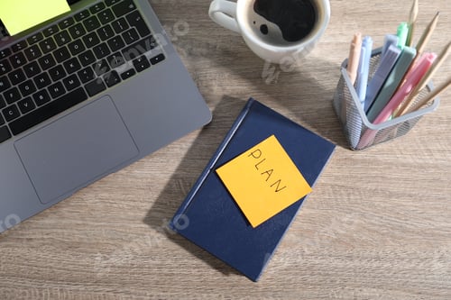 Preview: Laptop with colorful sticky notes, stationery and cup of coffee on wooden table, flat lay. Multitask