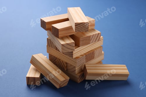 Preview: Stack of wooden blocks on blue background, closeup. Growth and strategy
