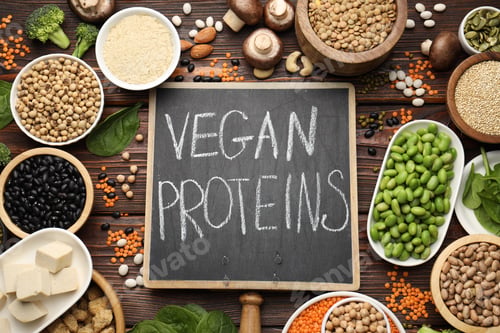 Preview: Board with phrase Vegan Proteins and different products on wooden table, flat lay